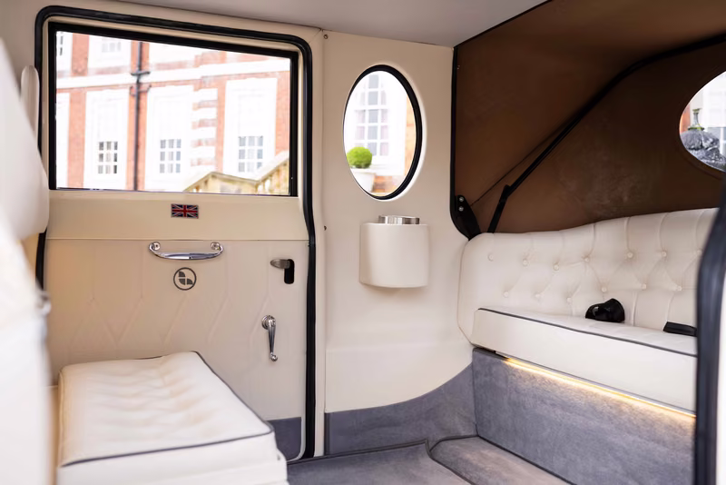 Century Imperial passenger cabin with ivory trim and seats, grey carpets and an oval side window.