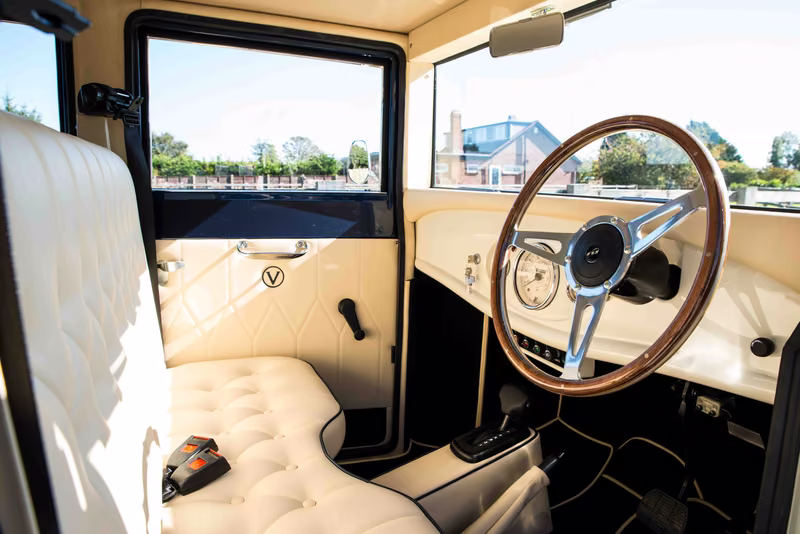 Imperial driving compartment with ivory upholstery, a cream instrument panel and wood-rim steering wheel.