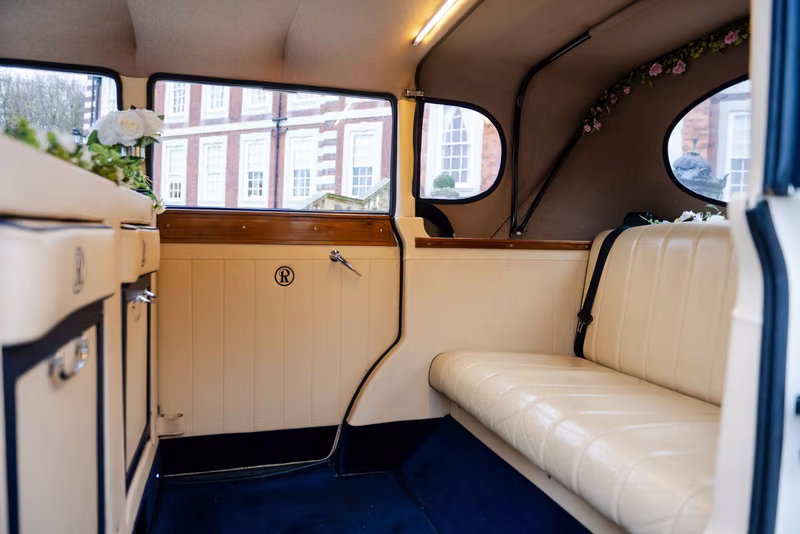 The Regent ivory rear bench and door trim, with wooden window trim and blue carpeting.